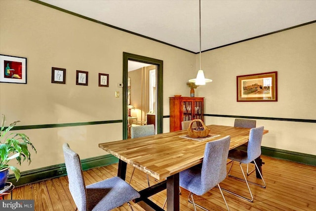 dining room featuring wood-type flooring and crown molding