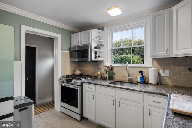 kitchen featuring sink, crown molding, light tile patterned floors, stainless steel appliances, and white cabinets