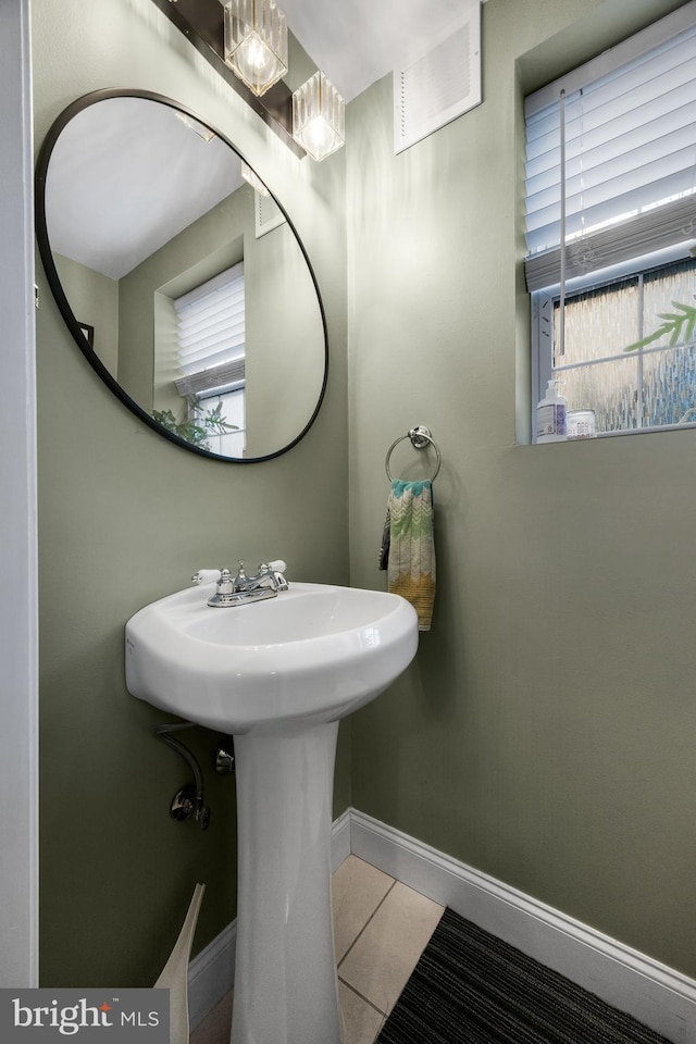 bathroom with tile patterned floors, a healthy amount of sunlight, and sink