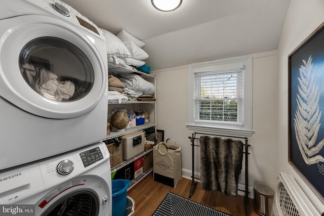 washroom featuring stacked washer / drying machine and dark wood-type flooring