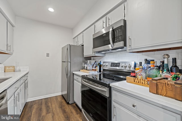 kitchen featuring white cabinetry, appliances with stainless steel finishes, dark wood-type flooring, and backsplash