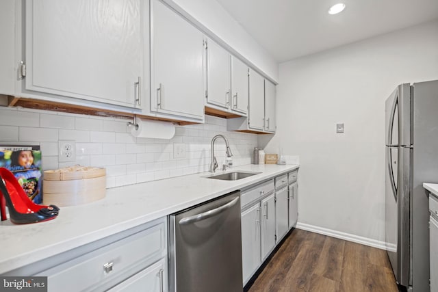 kitchen with sink, white cabinetry, dark hardwood / wood-style floors, stainless steel appliances, and backsplash