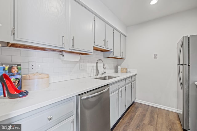 kitchen featuring sink, appliances with stainless steel finishes, backsplash, dark hardwood / wood-style floors, and white cabinets