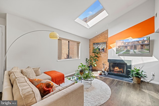 living room with hardwood / wood-style floors and vaulted ceiling with skylight