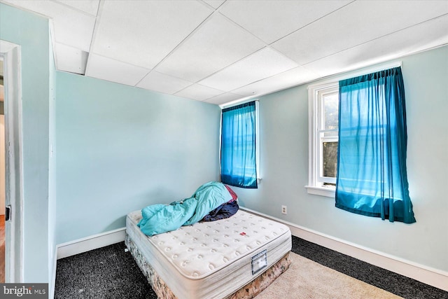 carpeted bedroom with a drop ceiling