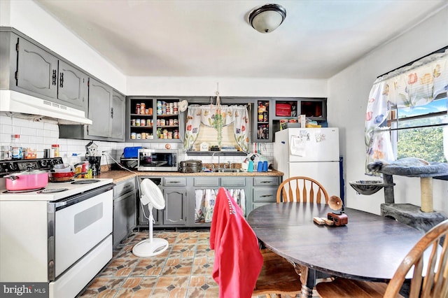 kitchen with sink, gray cabinetry, white appliances, and decorative backsplash