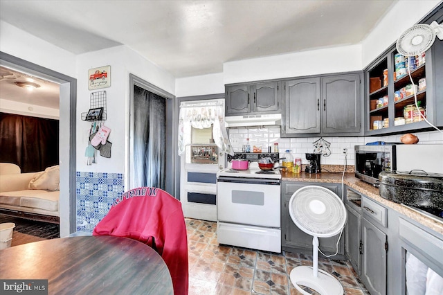 kitchen featuring white electric stove, gray cabinetry, and backsplash