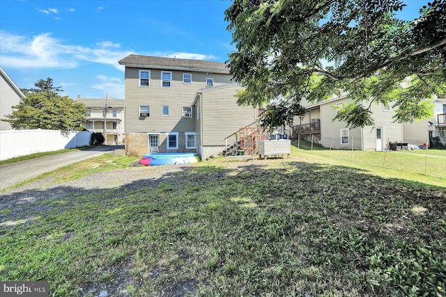 rear view of property featuring a lawn