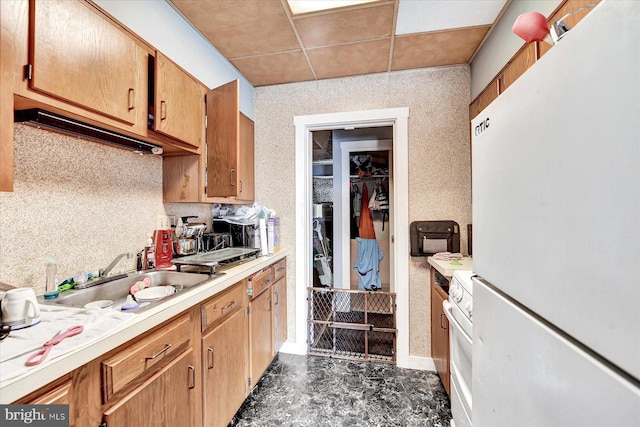 kitchen with sink, a paneled ceiling, and white appliances