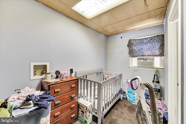 carpeted bedroom with cooling unit and a crib