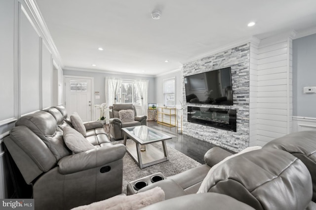 living room featuring crown molding, a large fireplace, and hardwood / wood-style floors