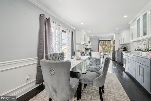 dining room with ornamental molding and dark hardwood / wood-style flooring