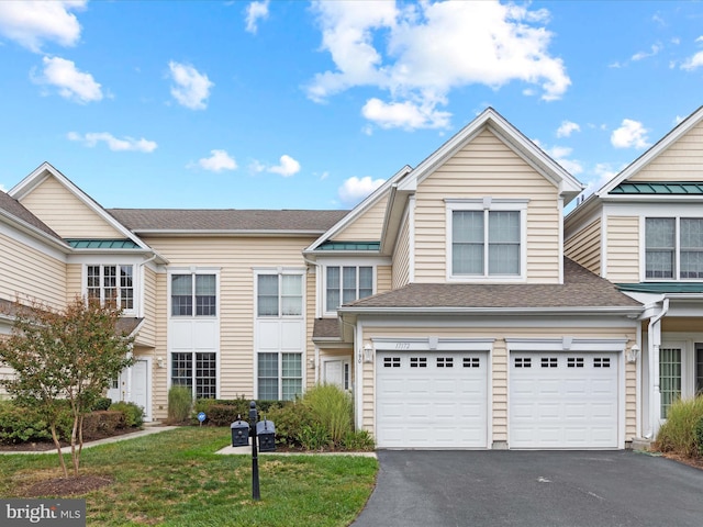 townhome / multi-family property with a garage and a front lawn