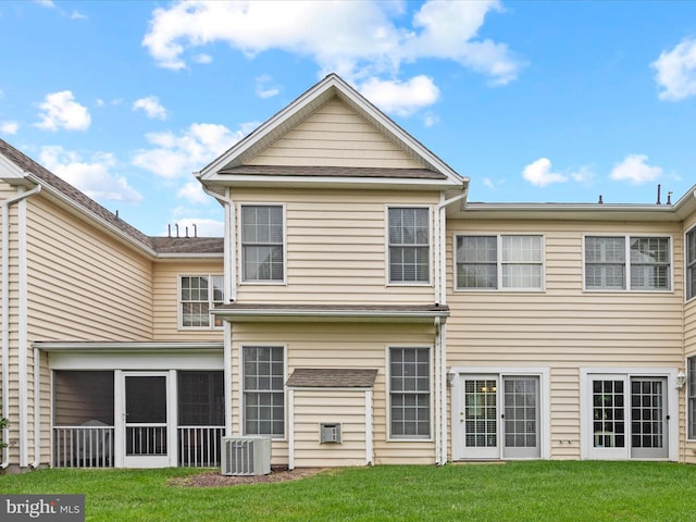 rear view of property featuring a yard, a sunroom, and central air condition unit