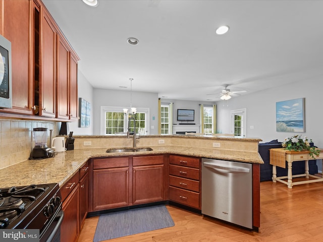 kitchen featuring sink, stainless steel dishwasher, kitchen peninsula, pendant lighting, and a healthy amount of sunlight