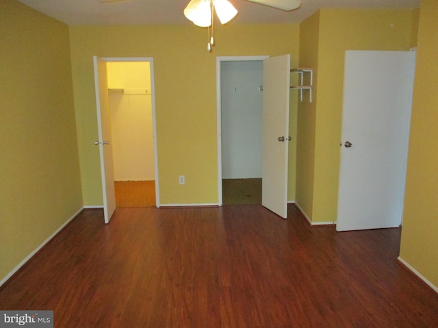 unfurnished bedroom with a walk in closet, dark hardwood / wood-style floors, and a closet