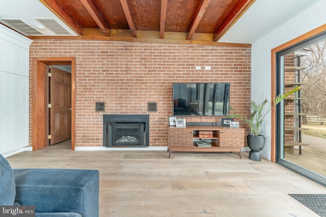 unfurnished living room featuring beam ceiling, a fireplace, and light hardwood / wood-style flooring