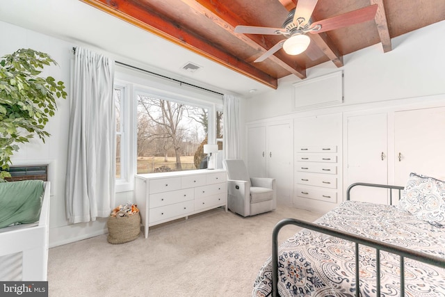 bedroom featuring light carpet and beam ceiling