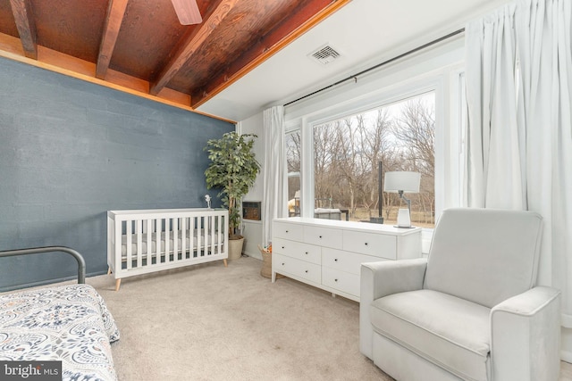 bedroom with light colored carpet and a nursery area