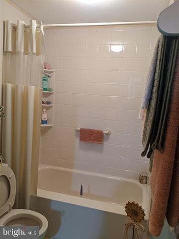 bathroom featuring toilet and shower / tub combo