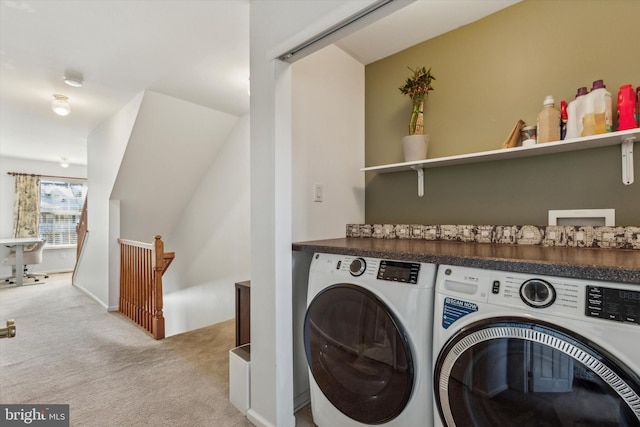 clothes washing area with light colored carpet and washer and clothes dryer