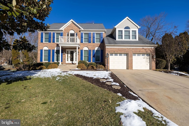 colonial inspired home with a garage and a front yard