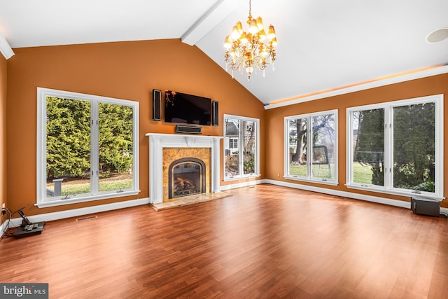 unfurnished living room with hardwood / wood-style flooring, beam ceiling, high vaulted ceiling, a fireplace, and a chandelier