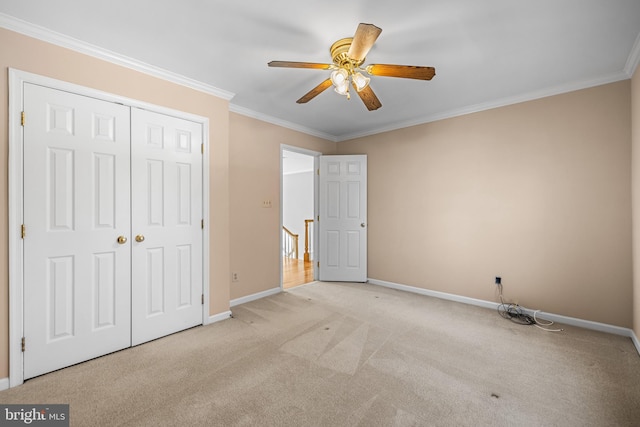 unfurnished bedroom with light colored carpet, ornamental molding, a closet, and ceiling fan