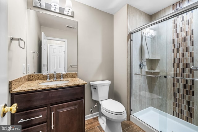 bathroom with a shower with door, vanity, hardwood / wood-style flooring, and toilet