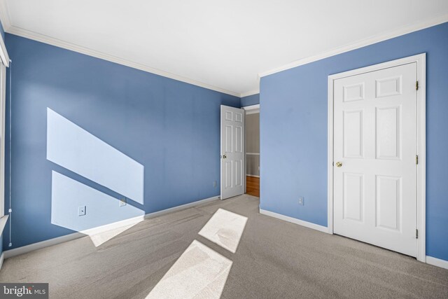 unfurnished bedroom featuring light carpet and crown molding