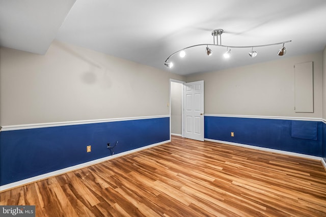 unfurnished room with track lighting and light wood-type flooring