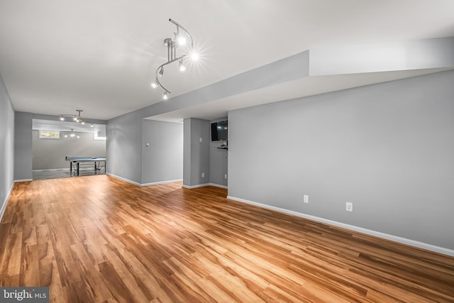 unfurnished living room with rail lighting and light hardwood / wood-style floors