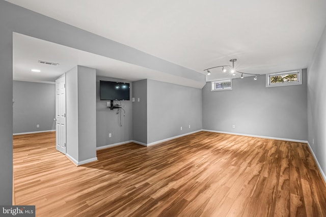 basement with light hardwood / wood-style flooring