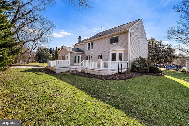 rear view of house featuring a deck and a lawn