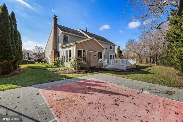 exterior space with a wooden deck, a front lawn, and a patio