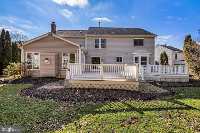 back of house with a wooden deck and a lawn