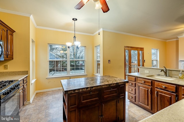 kitchen with crown molding, a center island, black gas stove, and sink