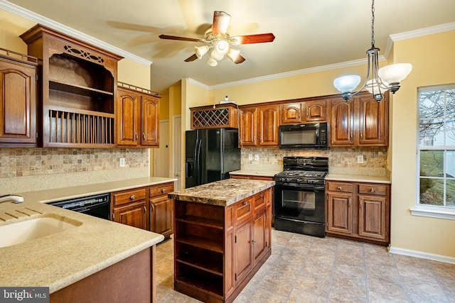 kitchen featuring sink, crown molding, decorative light fixtures, a center island, and black appliances