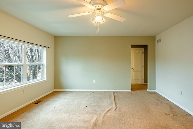 unfurnished room featuring light carpet and ceiling fan