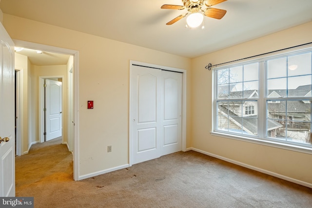 unfurnished bedroom with light colored carpet and a closet