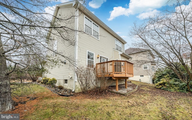 rear view of house with a wooden deck and a yard