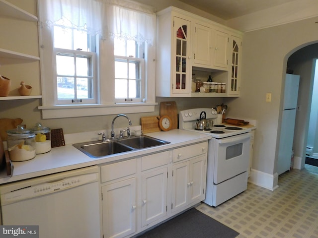 kitchen with white cabinetry, sink, and white appliances