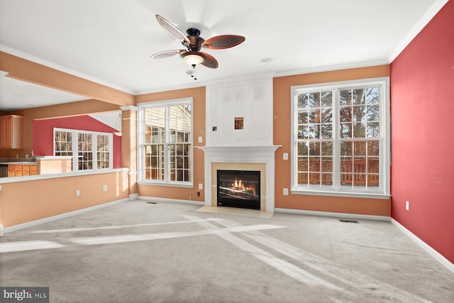 unfurnished living room with sink, crown molding, ceiling fan, and carpet