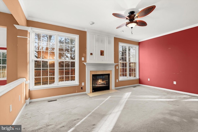 unfurnished living room with light carpet, ornamental molding, and ceiling fan