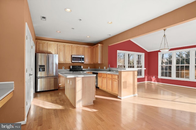 kitchen featuring a kitchen island, appliances with stainless steel finishes, hanging light fixtures, and lofted ceiling