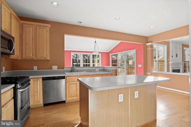 kitchen with a kitchen island, light brown cabinetry, sink, kitchen peninsula, and stainless steel appliances