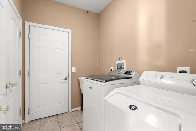 laundry area with light tile patterned floors and independent washer and dryer