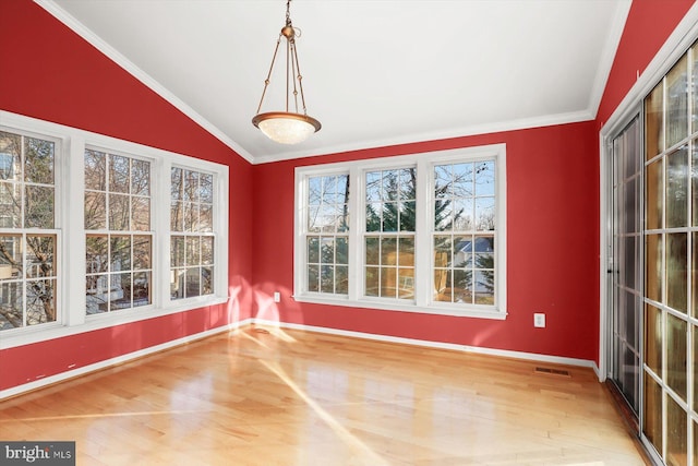 unfurnished dining area featuring hardwood / wood-style flooring, ornamental molding, and vaulted ceiling