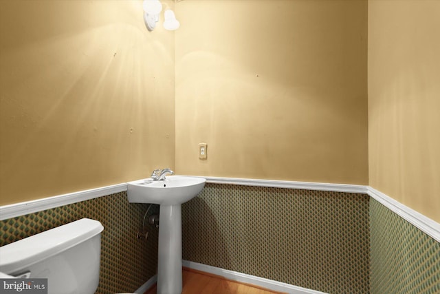 bathroom featuring hardwood / wood-style flooring and toilet