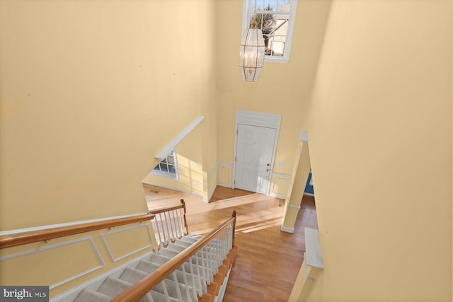 staircase featuring hardwood / wood-style floors and a notable chandelier